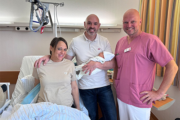 Glückliche Eltern mit Kind und Chefarzt